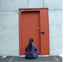 Woman sitting in front of a door 