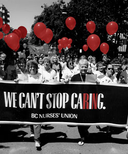 BCNU members marching with red balloons holding We Can't Stop Caring banner