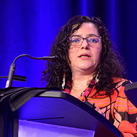 Aida Herrera speaking at the podium