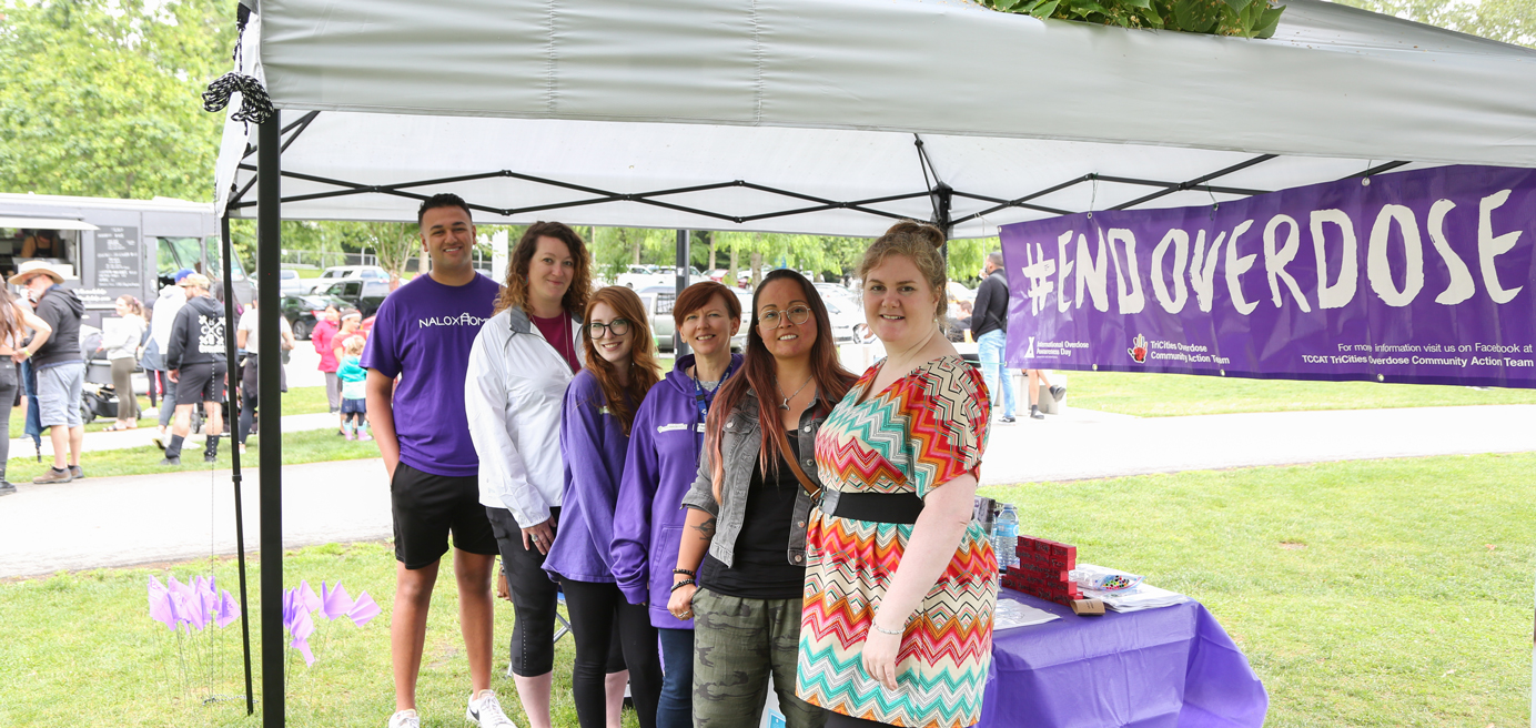 BCNU members standing underneath a tent with purple banner #endoverdose in the back