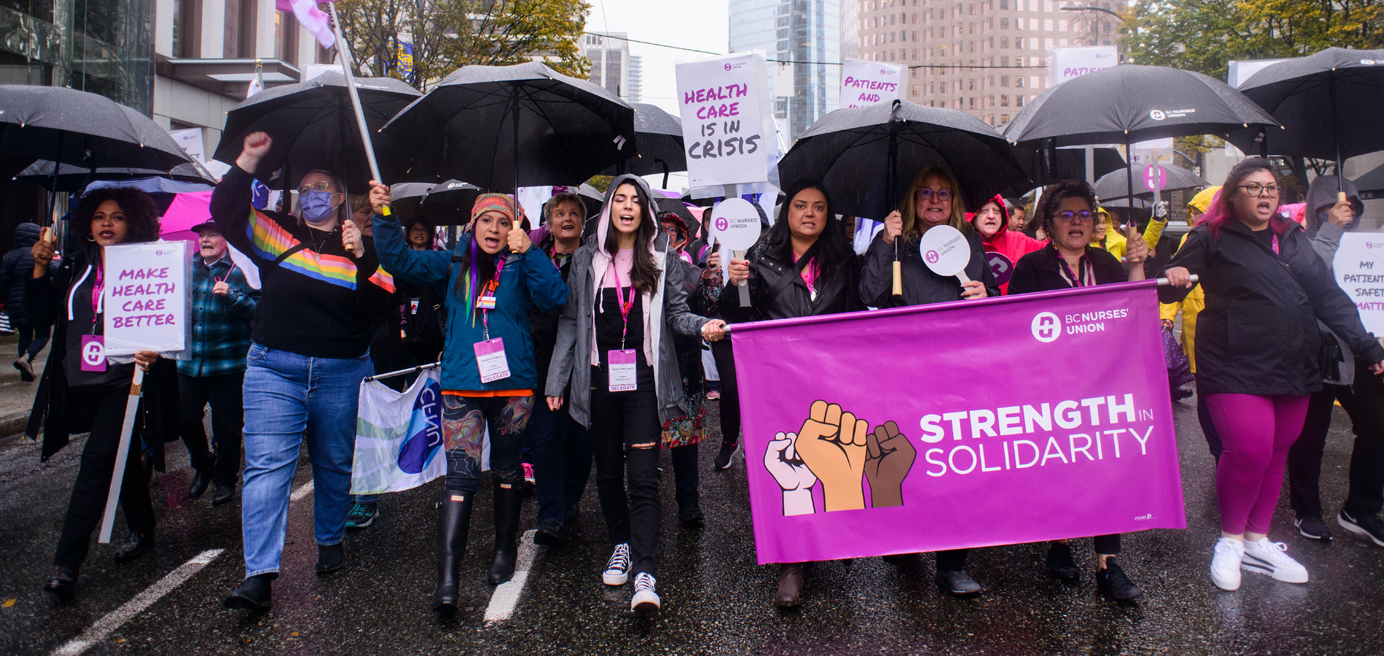 BCNU members marching in rally holding Strength in Solidarity banner