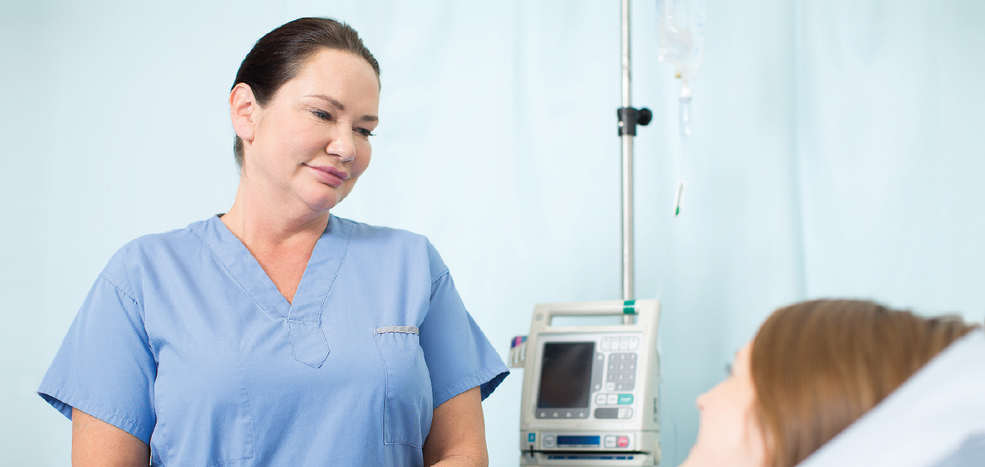 Nurse caring for patient in hospital bed