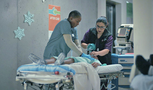 Two nurses giving CPR to a patient on a stretcher