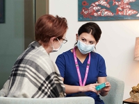 A senior and a nurse sitting together 