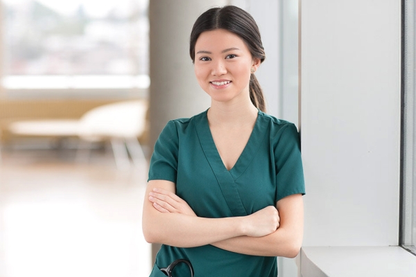 Nurse standing against window